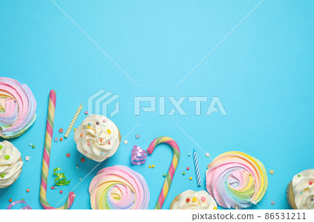 Flat lay composition with cupcakes on light blue background, space for text. Birthday party Flat lay composition with cupcakes on light blue background, space for text. Birthday party 86531211