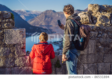Dad and son travelers in Montenegro in Kotor Old Town Ladder of Kotor Fortress Hiking Trail. Aerial drone view 86531894