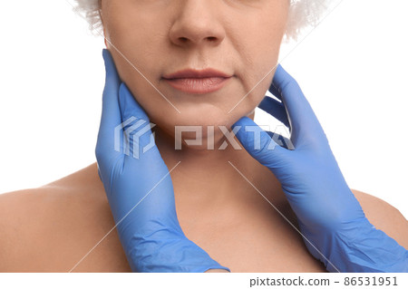 Doctor examining mature woman on white background, closeup. Double chin surgery Doctor examining mature woman on white background, closeup. Double chin surgery 86531951