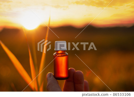 MOCKUP - a bottle of herbal oil, a beautiful sunset. MOCKUP - a bottle of herbal oil, a beautiful sunset. 86533106