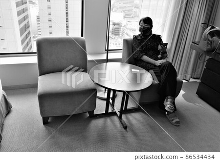 A woman relaxing on a sofa in a room on the upper floors of the hotel A woman relaxing on a sofa in a room on the upper floors of the hotel 86534434