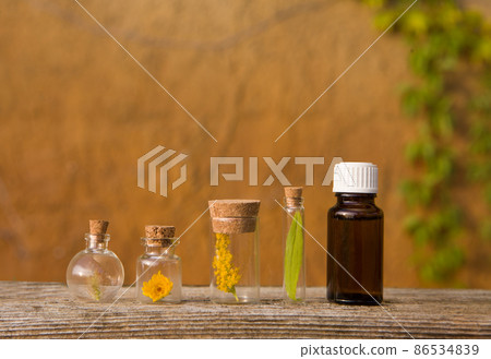 Bottles with herbs on a wooden board - blurry background, place for text 86534839