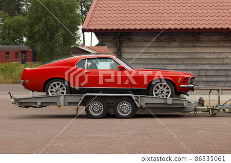Retro sport classic car on a flatbed truck. Car carrier trailer. 86535061