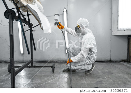 Painter in protective mask painting automobile door 86536271