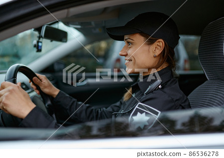 Side view portrait police woman driving car Side view portrait police woman driving car 86536278