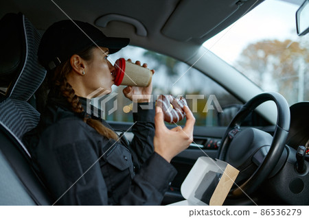 Female police officer having lunch during workday Female police officer having lunch during workday 86536279