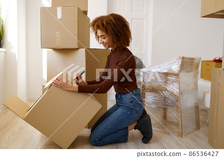 Side view portrait woman signing cardboard box Side view portrait woman signing cardboard box 86536427