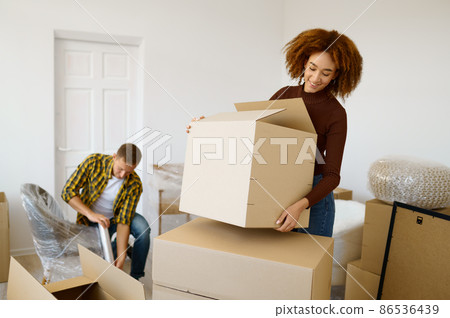 Happy couple packing beginnings before home moving Happy couple packing beginnings before home moving 86536439