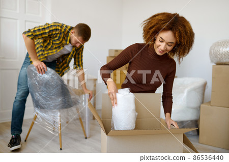 Happy couple packing beginnings before home moving Happy couple packing beginnings before home moving 86536440