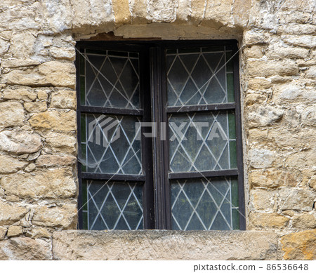 A window with decorative glass in the facade of a historic building. A window with decorative glass in the facade of a historic building. 86536648