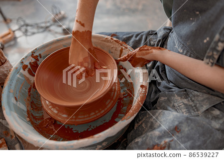 Skillful craftswoman creating earthen bowl on circle in art studio Skillful craftswoman creating earthen bowl on circle in art studio 86539227
