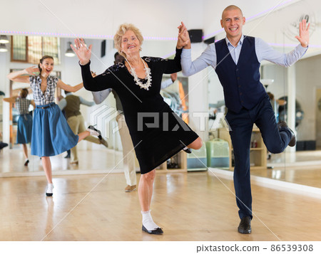 Mature woman learning to dance lindy hop with younger man  86539308