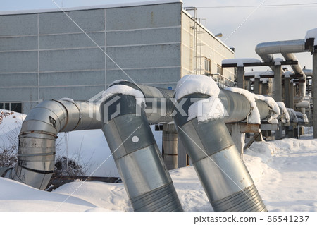 The main provides the city with hot water. Selective focus. The large pipes of the central heating system are covered with snow. Icicles on pipes. fuel crisis. Increasing the cost of heating. 86541237
