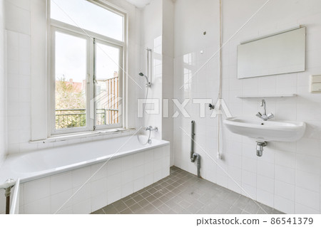 a bright old fashioned bathroom with white tiled walls 86541379