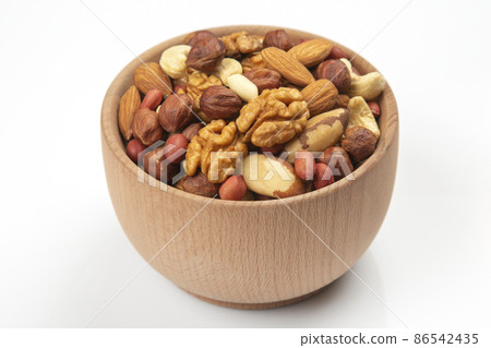 Different nuts in a wooden bowl on a white background. Vitamin wholesome food. 86542435