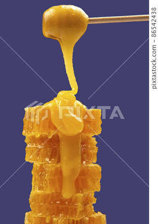 Fresh viscous flower honey falls down from a wooden spoon. vitamin organic food 86542438