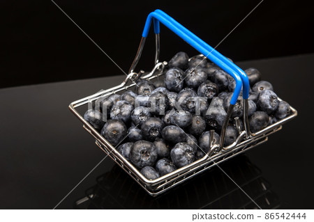 Fresh blueberries in a grocery basket on a background with a mirror image. vitamin food for health Fresh blueberries in a grocery basket on a background with a mirror image. vitamin food for health 86542444