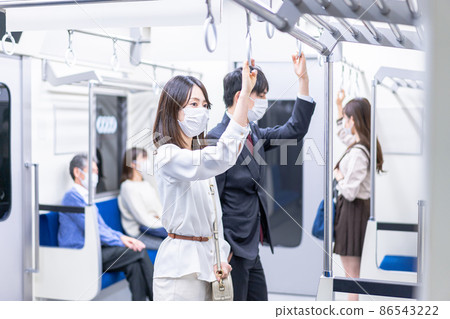 A young woman wearing a mask and traveling by train A young woman wearing a mask and traveling by train 86543222