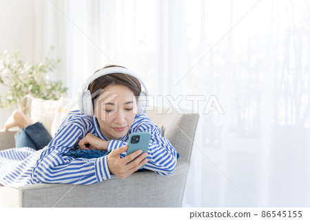 30 多歲的女性在沙發上放鬆 30 多歲的女性在沙發上放鬆 86545155