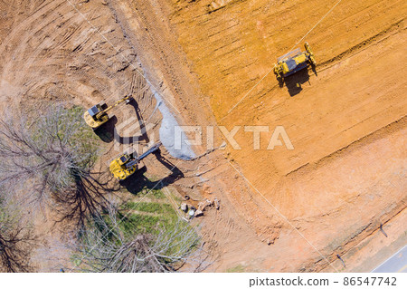 Dirt land leveled by a grader for the a new building construction 86547742