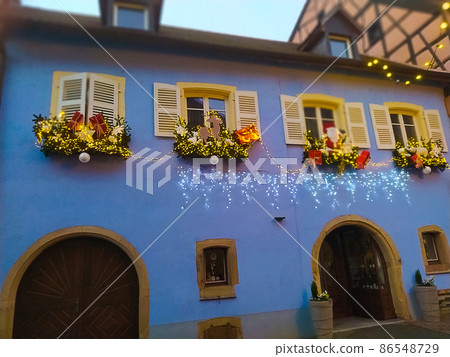 Morning scene in Eguisheim, a traditional village in the Alsace wine region of France, featuring a traditional house, now a wine degustation venue 86548729