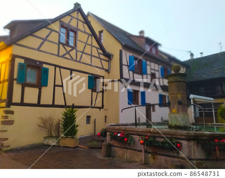 Morning scene in Eguisheim, a traditional village in the Alsace wine region of France, featuring a traditional house, now a wine degustation venue 86548731