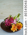 Dragon fruit and flowers on a wooden plate 86549048