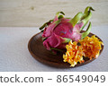 Dragon fruit and flowers on a wooden plate 86549049