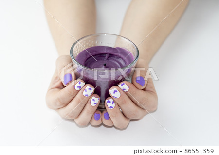The manicure is very peri. Mantkure for Valentine's Day in a very peri style. The hands hold a very peri candle. Ukriana February 5, 2022. 86551359
