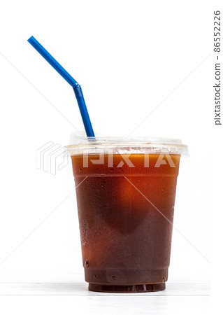 black coffee or ice americano in a cup with blue straw on white background black coffee or ice americano in a cup with blue straw on white background 86552226