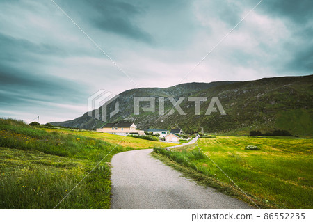Alnesgard, Godoya, Norway. Road In Alnesgard, Godoya. Old Houses In Summer Day In Godoy Island Near Alesund Town.Alnesgard, Godoya, Norway. Road In Alnesgard, Godoya. Old Houses In Summer Day In Godoy 86552235