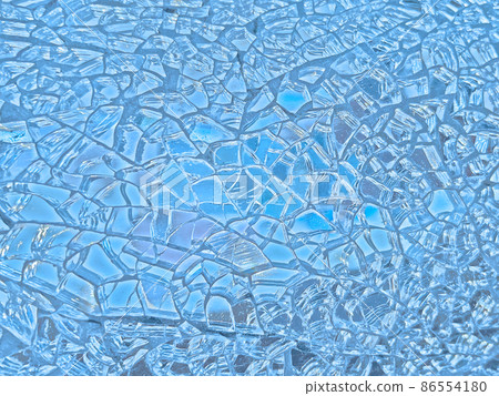 Background image of a finely cracked glass mirror that shines in aqua blue and pale violet 86554180