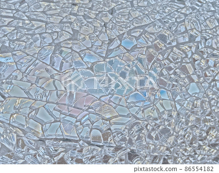 Background image of a finely cracked glass mirror that glows in silver or pale blue 86554182