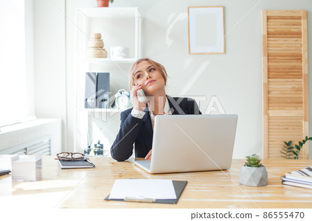 Young businesswoman using mobile phone in modern office 86555470
