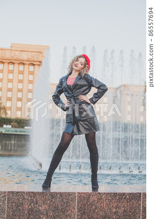 Outdoor full-length portrait of young elegant woman fashion model wearing red trench cap Outdoor full-length portrait of young elegant woman fashion model wearing red trench cap 86557694