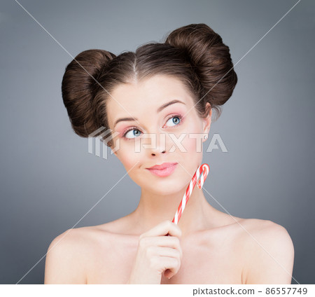 Attractive woman with Christmas candy smiling thinking and looking up 86557749
