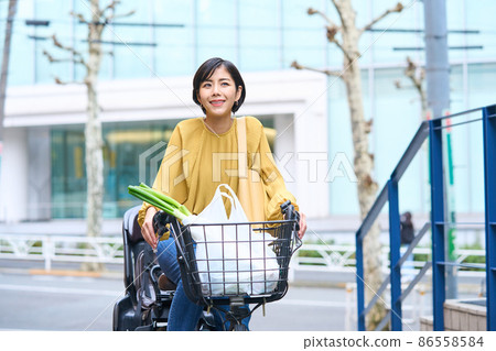 Mom riding a bicycle and shopping at a supermarket 86558584