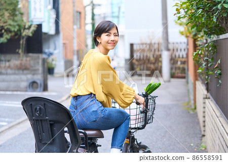 Mom riding a bicycle and shopping at a supermarket Mom riding a bicycle and shopping at a supermarket 86558591