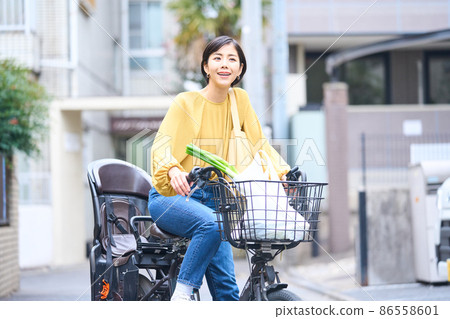 Mom riding a bicycle and shopping at a supermarket 86558601