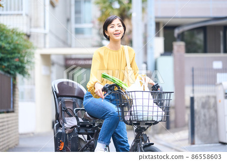 Mom riding a bicycle and shopping at a supermarket 86558603