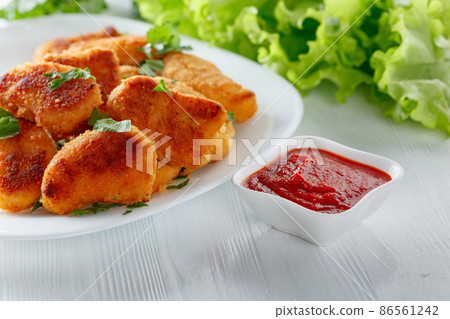 Fried chicken nuggets with ketchup. 86561242