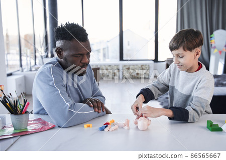 Little school boy playing doctor at home with his multiracial father Little school boy playing doctor at home with his multiracial father 86565667