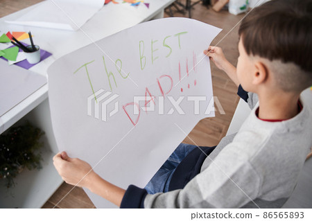 Caucasian boy holding placard with The best dad sign for the fathers day Caucasian boy holding placard with The best dad sign for the fathers day 86565893