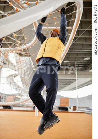 Young African American athlete in activewear pull up exercise 86567371