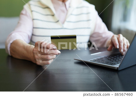 Hand of contemporary elderly woman with credit card Hand of contemporary elderly woman with credit card 86567460