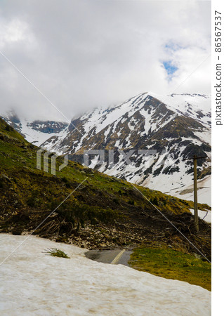 Mountain road littered with snow and trees. The convergence of an avalanche of snow. Clearing the road. Mountain road littered with snow and trees. The convergence of an avalanche of snow. Clearing the road. 86567537