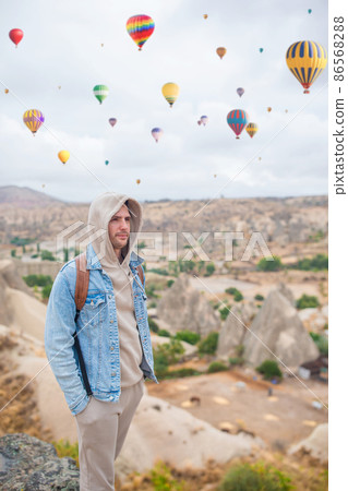 Happy young man watching hot air balloons in Cappadocia, Turkey 86568288