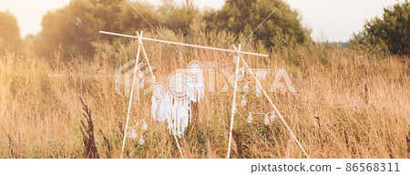 White cotton dreamcatcher at natural background, soft selective focus, toned, banner White cotton dreamcatcher at natural background, soft selective focus, toned, banner 86568311