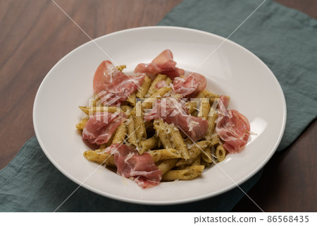 Penne pasta with capocollo, pesto and parmesan cheese Penne pasta with capocollo, pesto and parmesan cheese 86568435