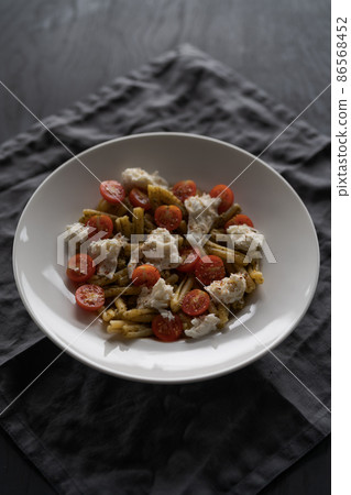 casarecce pasta with pesto, fresh cherry tomatoes and mozzarella 86568452